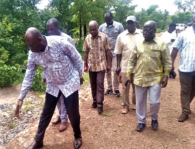  Collins Augustine Ntim (left), a Deputy Minister of MLGDRD,  inspecting the feeder road project
